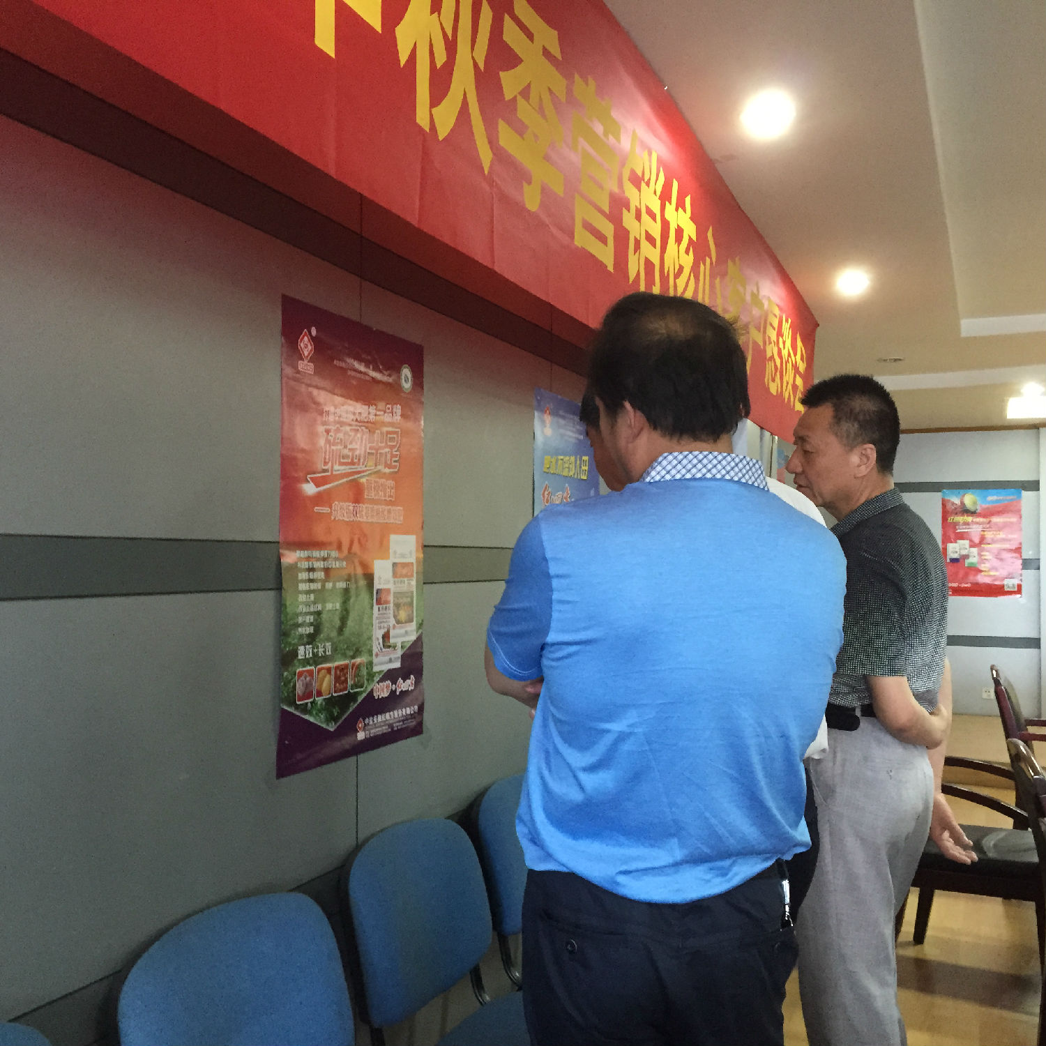 會議前，復合肥經(jīng)銷商正在觀看廳里掛的宣傳海報