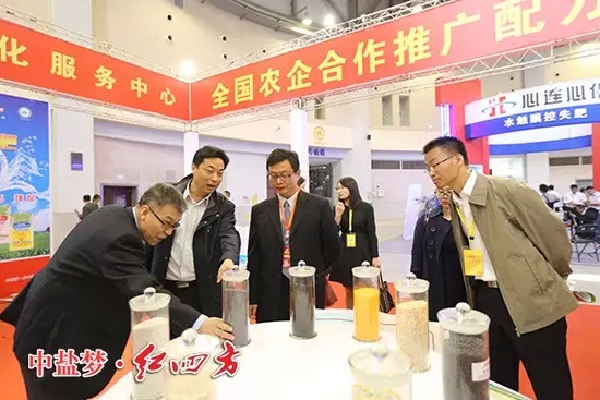 全國農(nóng)技推廣中心副主任謝建華、全國農(nóng)技推廣中心土肥處處長辛景樹仔細研究紅四方新型肥料。
